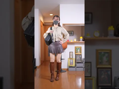 茶色のフェイクレザープリーツミニスカートにベージュストッキングのコーデです
